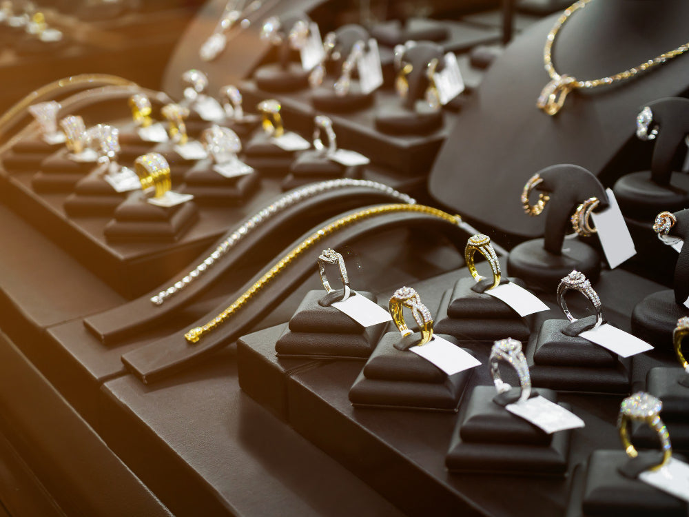 Joyas expuestas en una vitrina de una joyería donde se ven anillos, collares y pulseras